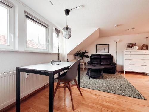 a dining room with a table and a chair at SkyNest Pirna gemütliches Dachstudio mit Stadtblick in Pirna