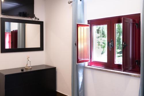 a bathroom with red windows and a mirror at Geres parque in Geres