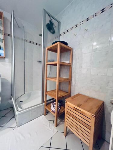 a bathroom with a shower and a wooden shelf at Ocean View Laboe in Laboe