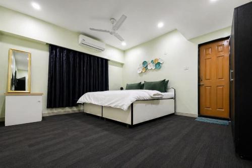 a bedroom with a bed and a window and a door at StayLuxe Rooms & Apartments Near BKC, Chembur in Mumbai
