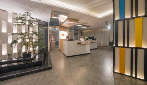 a lobby with a counter and plants in a building at Ewaa Express Hotel - Yanbu Alamarah in Yanbu