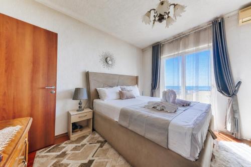 a bedroom with a large bed with a large window at Studio Apartments S in Dobra Voda