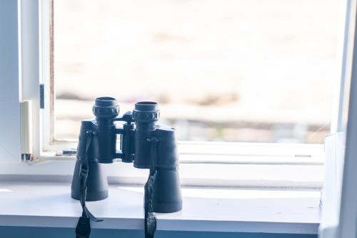 a pair of binoculars sitting on a window sill at La Rose des Mers in Tréffiagat
