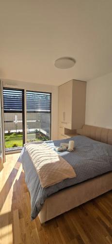a bedroom with a large bed with a large window at Sunlit Oasis Garden in Postojna