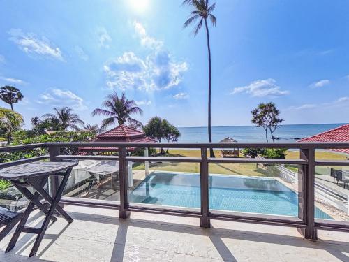 a balcony with a swimming pool and the ocean at Beachfront! 4 Bedrooms - Malee Beach Villa E6 in Phra Ae beach