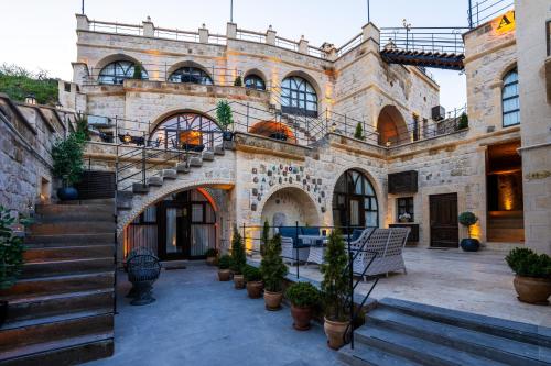 a large stone building with stairs and potted plants at Aurelia Cave Cappadocia - Special Class in Nevşehir