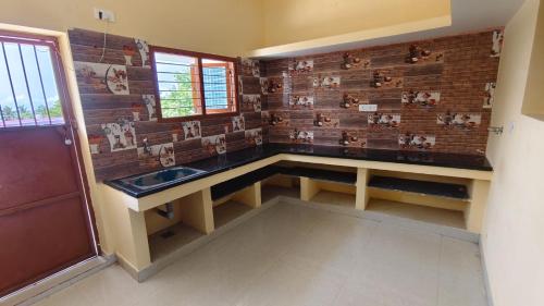 a bathroom with a sink and a brick wall at Priyan Beach View Residency in Kuilapayam