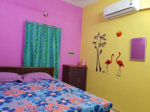 a bedroom with a bed with pink and yellow walls at Priyan Beach View Residency in Kuilapayam