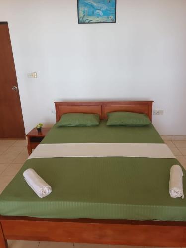a bed with two pillows on it in a room at Jasmin Garden in Kalutara
