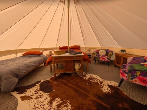 a room with a tent with a bed and a table at Private Luxury Glamping surrounded by wildlife in Pembrokeshire