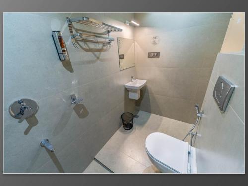 a bathroom with a toilet and a sink at Aywa Hotels Edapally in Cochin
