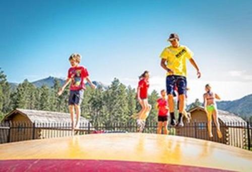 a group of children jumping on top of a trampoline at Lodge at Palmer Gulch in Hill City