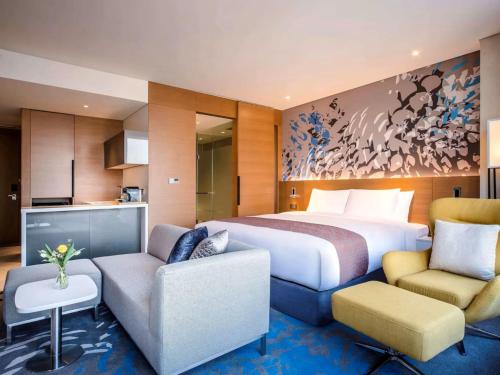 a hotel room with a bed and two chairs at Hotel Daira Suite Near IGI Airport Delhi in New Delhi
