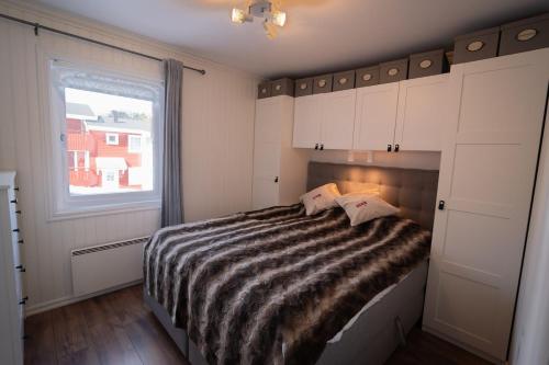 a bedroom with a large bed with a window at Central Ski-In Ski-Out Apartment in Vemdalen