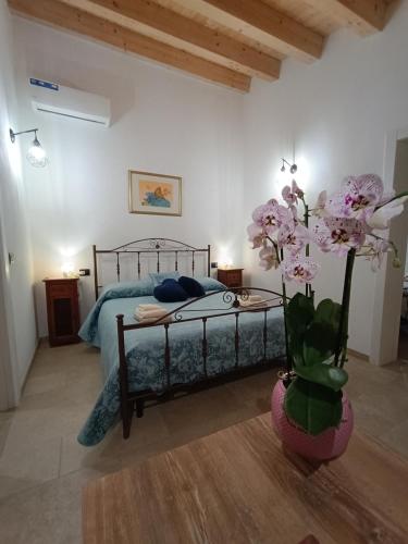 a bedroom with a bed and a vase of flowers at Borghetto Meti in Avola