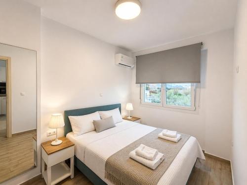 a bedroom with a large bed with two towels on it at Nefeli's 13,6 Apartment in Orfánion