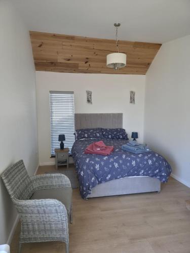a bedroom with a bed and a chair at Downside Annexe in Woolacombe