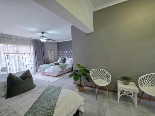 a bedroom with a bed and a couch and chairs at Grey Crescent living in Welkom