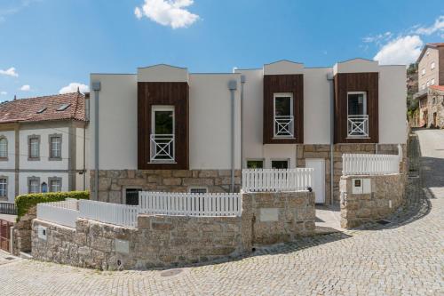 a building with a stone wall in front of it at StoneBridge Riverside Mountain Apartments in Loriga