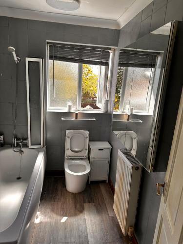 a bathroom with a toilet and a tub and a sink at 5 Bedroom house Doncaster in Balby