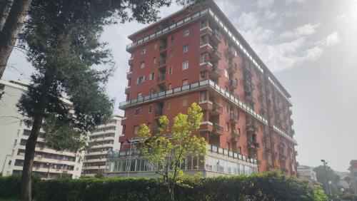a tall red brick building in a city at Park & Seafront Pescara in Montesilvano