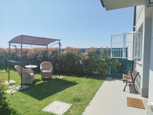 a yard with two chairs and a gazebo at Appartamento B&B Cà Betty in Calderara di Reno