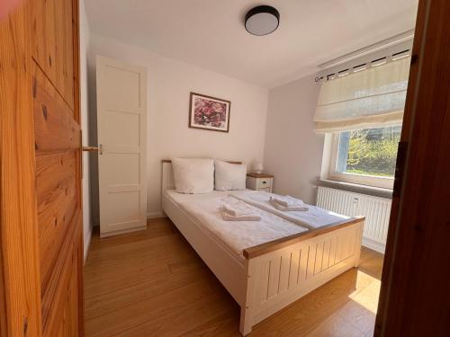 a bedroom with a white bed with a window at Landhaus Buckow in Buckow