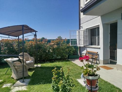 a patio with an umbrella and a chair and a table at Appartamento B&B Cà Betty in Calderara di Reno