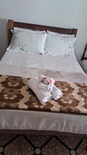 a bed with a blanket and towels on it at Camping e Pouso Recanto das Flores in Tiradentes