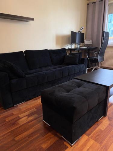 a living room with a black couch and a table at Elegancki apartament w centrum in Warsaw
