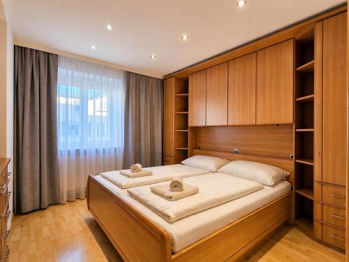 a bedroom with a large bed and a large window at Seehaus Gori in Maria Wörth