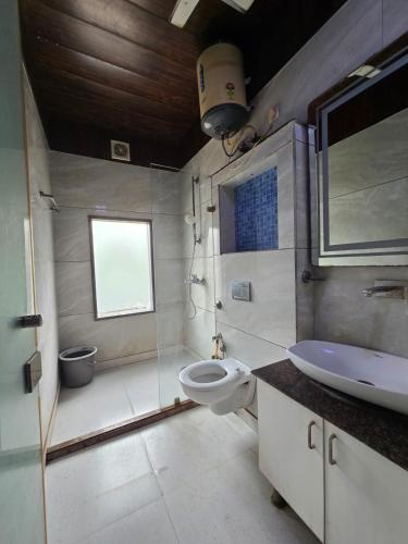 a bathroom with a toilet and a sink at Hotel Mannat Shalimar in New Delhi