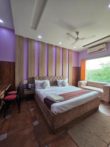 a bedroom with a large bed with purple walls at Hotel Mannat Shalimar in New Delhi