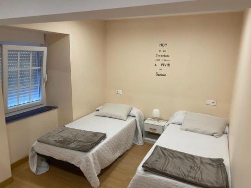 a hospital room with two beds and a window at Casa Lameiro in Cedeira