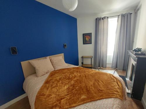 a blue bedroom with a bed and a blue wall at Le Palais Des Marins in Châteauroux