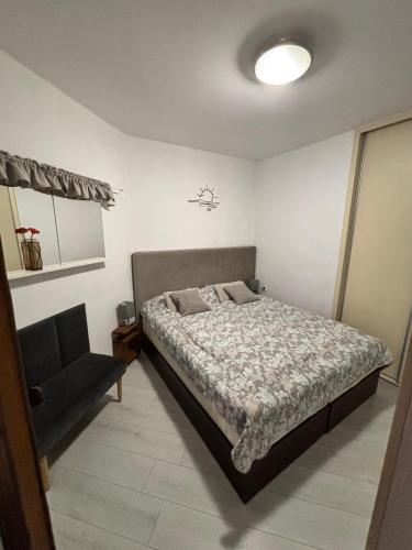 a bedroom with a bed and a chair in it at Apartament Patio 50 m od plaży in Władysławowo