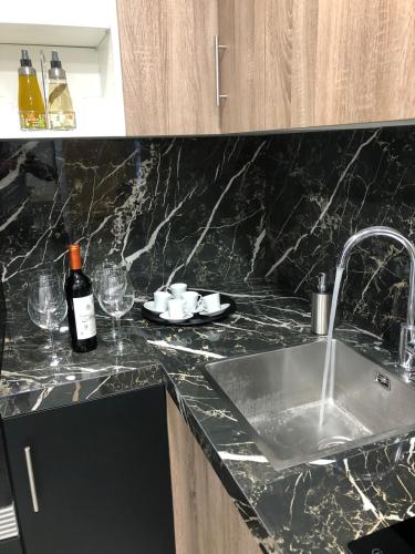 a kitchen counter with a sink and a bottle of wine at Apart LA PLANA II in Castellón de la Plana