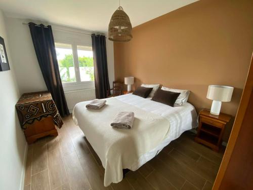 a bedroom with a bed with two towels on it at Frangipanier, Maison quartier calme, 1,5km de la plage, 6 pers in Les Sables-d'Olonne