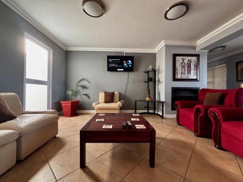 a living room with a red couch and a table at Wild Thyme in St Helena Bay in West Point