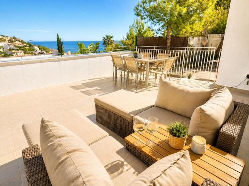 a patio with a couch and a table on a balcony at Casa del Sol Jacuzzi privado y vistas al Mediterráneo en Altea Hills in Altea