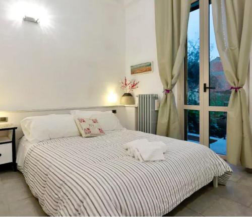 uma cama branca num quarto com uma janela em Garden in Florence em Florença
