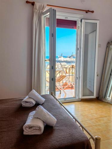 a bedroom with towels on a bed with a view of the ocean at Boutique Florence in Ermoupoli