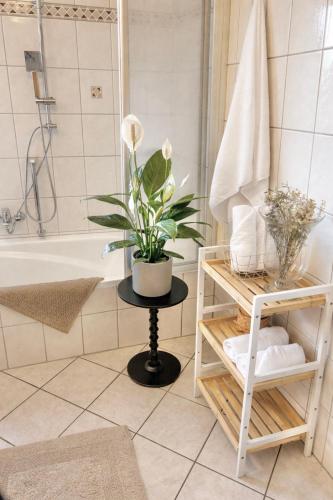 a bathroom with a plant on a table next to a bath tub at Auszeit in Bullay