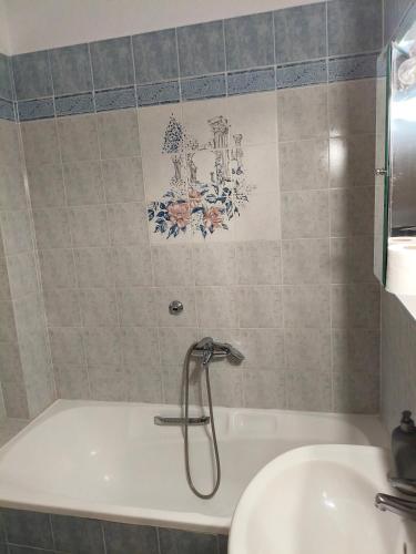 a bathroom with a bath tub and a sink at Hotel Galaxias in Kato Loutraki
