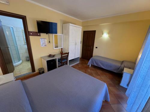 a hotel room with two beds and a desk at Il Melograno in Nicotera Marina