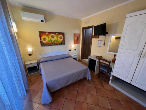 a bedroom with a bed and a desk and a television at Il Melograno in Nicotera Marina
