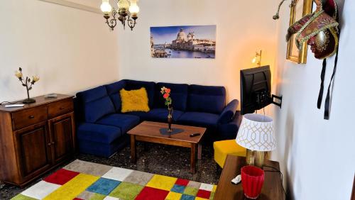 a living room with a blue couch and a tv at Calle Bottari ChioggiaPL in Chioggia