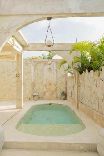 a large swimming pool in a room with an arch at CASA NARA BALI in Canggu