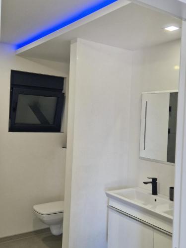 a white bathroom with a toilet and a sink at Villa Maja in Sutomore
