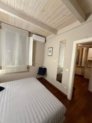 a bedroom with a white bed and a window at Martina Fillungo Loft in Lucca
